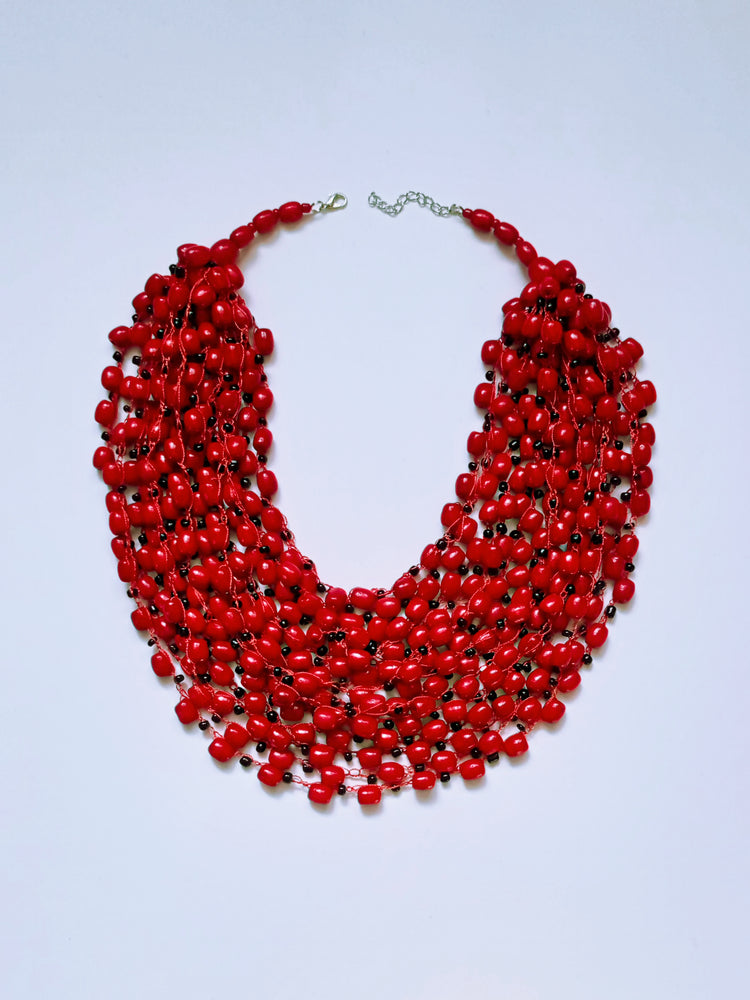 Glossy red bead necklace with occasional black speckles