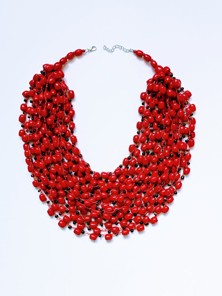 Glossy red bead necklace with occasional black speckles